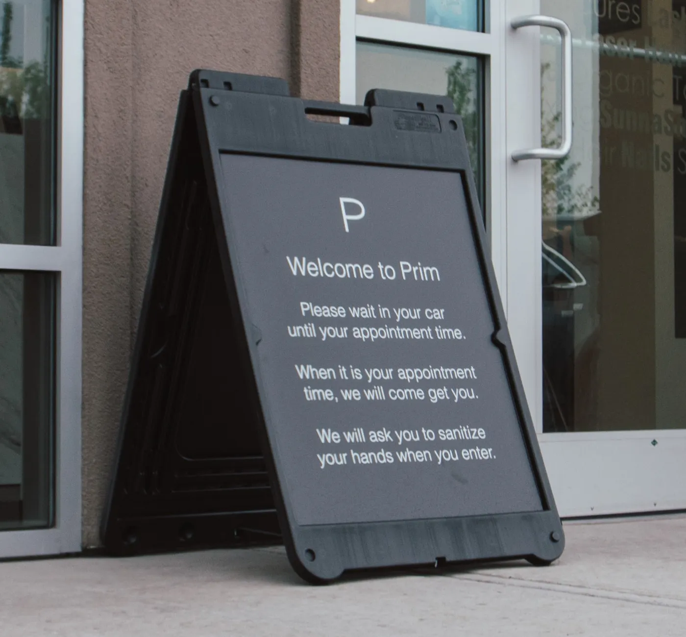 Black sandwich board sign at a store entrance